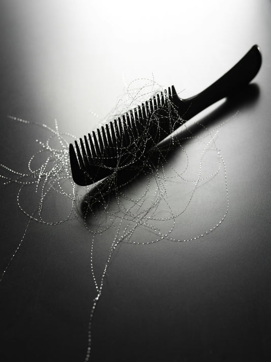 A black comb with strands of hair on it.